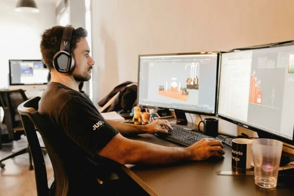 Person ved 2 computer skærme